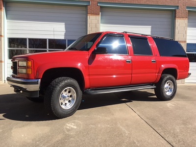 Lift kit installed on Red Chevrolet Suburban